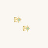 Gold star-shaped earrings with gemstones on a white background